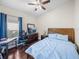 Bedroom featuring wood floors, a ceiling fan, a wooden bed frame, and blue bedding at 13302 Trailing Moss Dr, Dade City, FL 33525