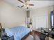 Cozy bedroom featuring dark wood floors, a ceiling fan, and a closet at 13302 Trailing Moss Dr, Dade City, FL 33525