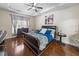 This bedroom has a large wooden bed, hardwood floors, and natural light at 13302 Trailing Moss Dr, Dade City, FL 33525