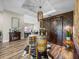 Rustic dining area featuring wooden floors, a barrel table, barn doors, and unique barrel chandelier at 13302 Trailing Moss Dr, Dade City, FL 33525