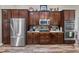 Modern kitchen featuring stainless steel appliances, dark wood cabinets, granite countertops, and hardwood floors at 13302 Trailing Moss Dr, Dade City, FL 33525