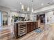 Stylish kitchen island with wine cooler, stainless steel appliances, and granite countertops open to living area at 13302 Trailing Moss Dr, Dade City, FL 33525