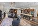 Open concept living room featuring a kitchen island and a separate dining space, hardwood floors, and modern decor at 13302 Trailing Moss Dr, Dade City, FL 33525