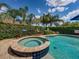 This pool features a jacuzzi and well manicured landscape at 13302 Trailing Moss Dr, Dade City, FL 33525