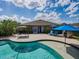 Inviting backyard pool with brick patio, lounge chairs, and lush tropical landscaping perfect for relaxing and entertaining at 13302 Trailing Moss Dr, Dade City, FL 33525