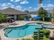 Backyard pool and spa with an umbrella, lounge chairs, and a swing at 13302 Trailing Moss Dr, Dade City, FL 33525
