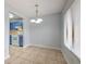 Dining area features tile flooring, a modern light fixture, and flows into the kitchen with blue cabinets at 1424 Highland Ridge Cir, Brandon, FL 33510