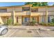 Beige two-story townhouse featuring a welcoming entrance, small garden, and convenient parking spaces at 1424 Highland Ridge Cir, Brandon, FL 33510