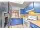 Updated kitchen with blue cabinetry, tile flooring, modern appliances, and a stainless steel double sink at 1424 Highland Ridge Cir, Brandon, FL 33510