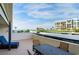 Spacious balcony with comfortable seating and a dining table overlooking ocean and beachfront condos at 1460 Gulf Blvd # 108, Clearwater, FL 33767