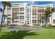 Luxury high-rise beachfront condo building with lush landscaping, circular driveway, and direct beach access at 1460 Gulf Blvd # 108, Clearwater, FL 33767