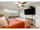 Bedroom featuring a queen bed, TV, closet, and large window offering plenty of natural light at 1701 Pinehurst Rd # 31D, Dunedin, FL 34698