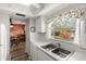 Bright kitchen with stainless steel sink, tile backsplash, and window with shell-themed curtains at 1701 Pinehurst Rd # 31D, Dunedin, FL 34698