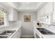 Galley kitchen featuring white appliances and cabinetry, nautical decor, and bright natural light at 1701 Pinehurst Rd # 31D, Dunedin, FL 34698