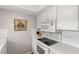Close up of kitchen area with white appliances, white countertops, white backsplash, and flat panel cabinets at 1701 Pinehurst Rd # 31D, Dunedin, FL 34698