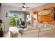 Comfortable living room featuring a leather sofa, patio access, and beach-inspired wall decor at 1701 Pinehurst Rd # 31D, Dunedin, FL 34698