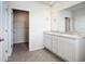Bright bathroom featuring a double sink vanity with granite counters and a walk-in closet at 18023 Canopy Pl, Bradenton, FL 34211