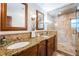 Well-lit bathroom with a double vanity, granite countertop, and walk-in glass shower at 1868 Juarez S Way, St Petersburg, FL 33712
