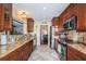 Galley kitchen features wood cabinets, granite countertops, and stainless steel appliances at 1868 Juarez S Way, St Petersburg, FL 33712