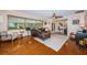 Spacious living room with hardwood floors, large windows, a ceiling fan, and a comfortable leather sofa at 1868 Juarez S Way, St Petersburg, FL 33712