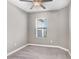Neutral bedroom with large window offering neighborhood views and ceiling fan at 18737 Noble Caspian Dr, Lutz, FL 33558