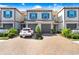 Close up of the townhome featuring a brick driveway, two car garage and blue shutters at 18737 Noble Caspian Dr, Lutz, FL 33558
