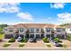 Townhome exterior featuring blue shutters, garages and brick driveways set under a bright blue sky at 18737 Noble Caspian Dr, Lutz, FL 33558