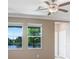 Bright living room with two windows overlooking a pond and a ceiling fan with light fixture at 18737 Noble Caspian Dr, Lutz, FL 33558