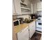 Efficient kitchen featuring white cabinets and appliances, including a microwave and a dishwasher at 1903 Canterbury Ln # B2, Sun City Center, FL 33573