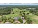 Aerial view of a golf course community with lush greenery, mature trees and a large building with circular drive at 19529 Lily Pond Ct, Brooksville, FL 34601
