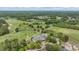 Scenic aerial view of golf course with mature trees and a building with circular drive at end of winding road at 19529 Lily Pond Ct, Brooksville, FL 34601