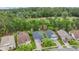 Aerial view of several homes showing roof lines, landscaping, and proximity to a densely wooded area at 19529 Lily Pond Ct, Brooksville, FL 34601