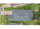 An aerial view shows the home's roof, driveway, and screened-in patio set against a backdrop of mature trees at 19529 Lily Pond Ct, Brooksville, FL 34601