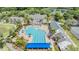 Aerial view of the aquatic center and pool featuring tropical landscaping, tennis courts, and a lake at 19529 Lily Pond Ct, Brooksville, FL 34601