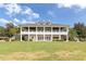 Large southern-style home featuring a sprawling lawn with grand columns and a covered balcony at 19529 Lily Pond Ct, Brooksville, FL 34601
