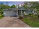 Charming single-story home featuring a covered front porch, manicured landscaping, and brick driveway at 19529 Lily Pond Ct, Brooksville, FL 34601