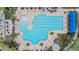 Aerial view of a resort style swimming pool with a slide, tanning chairs, and lush tropical landscaping at 19529 Lily Pond Ct, Brooksville, FL 34601
