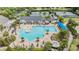 Aerial view of a resort style swimming pool with tennis courts and tropical landscaping in the background at 19529 Lily Pond Ct, Brooksville, FL 34601