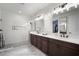 Elegant bathroom featuring dual vanities, a walk-in shower, and pristine white finishes at 28853 Seedling St, Wesley Chapel, FL 33543