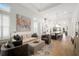 Open-concept living room with hardwood floors, comfortable seating, and modern decor. Seamless flow to kitchen at 28853 Seedling St, Wesley Chapel, FL 33543