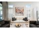 Comfortable living room with sofa, armchairs, area rug, neutral colors, and natural light through large windows at 28853 Seedling St, Wesley Chapel, FL 33543