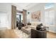 Spacious living room featuring comfortable seating, neutral decor, wood floors, and large windows for natural light at 28853 Seedling St, Wesley Chapel, FL 33543