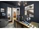 Stylish home office boasts dark walls, modern art, a wood desk, and natural light through glass paneled doors at 28853 Seedling St, Wesley Chapel, FL 33543