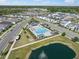 Aerial view of a neighborhood pool with lounge chairs, playground and a water feature in an adjacent pond at 28853 Seedling St, Wesley Chapel, FL 33543