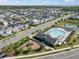 Aerial view of a neighborhood pool with lounge chairs, playground and a water feature in an adjacent pond at 28853 Seedling St, Wesley Chapel, FL 33543