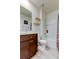 This charming bathroom features tiled floors, a shower-tub combo, and floating shelves at 2933 Maiden Grass Isle, Wesley Chapel, FL 33543