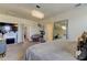 Well-lit bedroom showcasing a statement mirror, cozy chair, and fireplace with TV at 2933 Maiden Grass Isle, Wesley Chapel, FL 33543