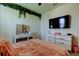 Cozy bedroom with decorative ivy wall decor, TV and vanity at 2933 Maiden Grass Isle, Wesley Chapel, FL 33543
