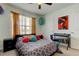 Bright bedroom with colorful decor, ceiling fan, and large window offering natural light at 2933 Maiden Grass Isle, Wesley Chapel, FL 33543