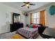 Bright bedroom with colorful decor, ceiling fan, and large window offering natural light at 2933 Maiden Grass Isle, Wesley Chapel, FL 33543
